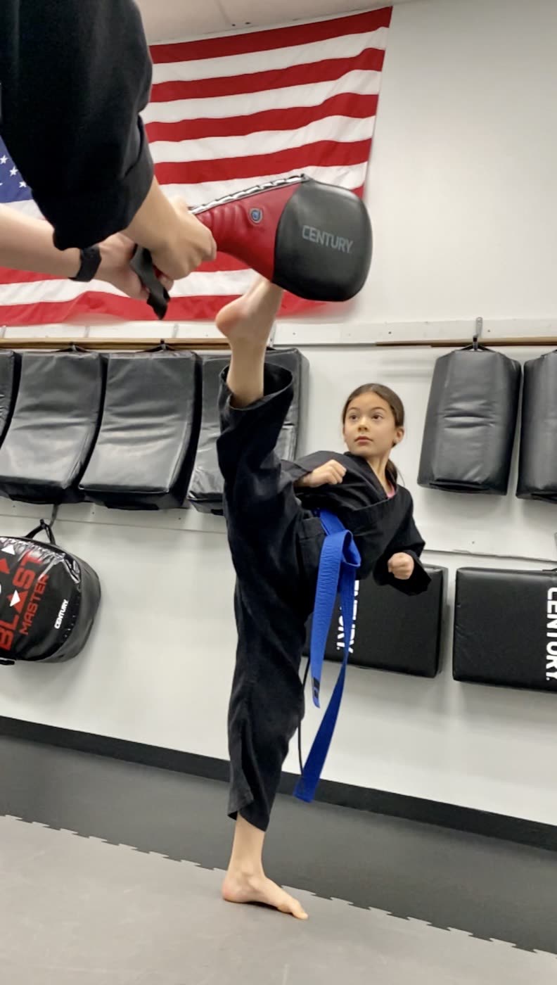 A teen student practicing a high kick at Tearney's